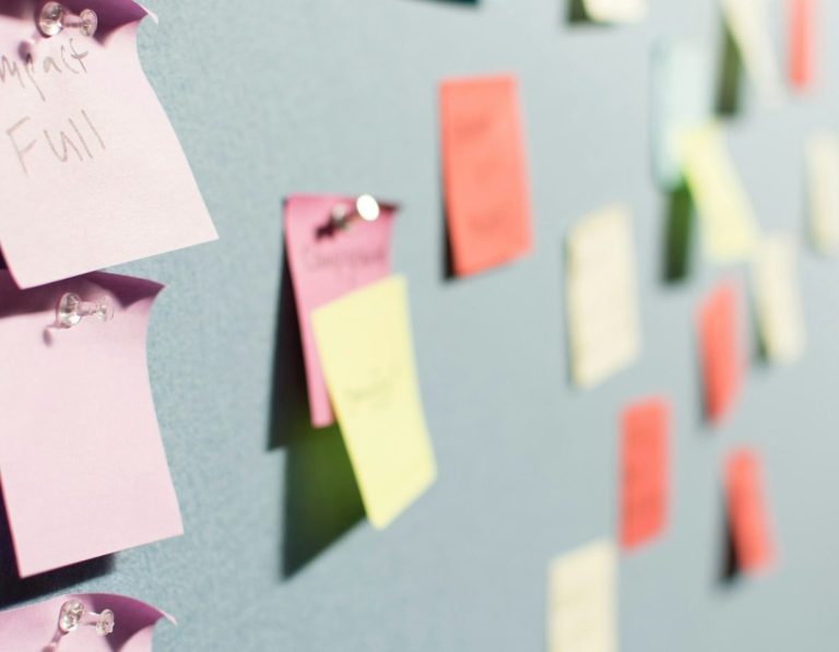 Foto von Patrick Perkins von Unsplash Bunte Haftnotizen an einer grauen Wand, verschiedene Farben und Formen.
